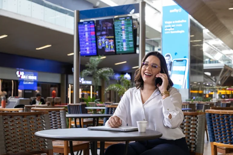 mulher no celular trabalhando com gestão de viagens sob medida